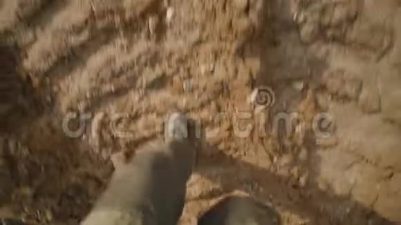 成年男子的靴子从上到下在泥地上行走视频的预览图