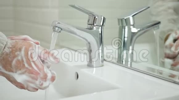 在卫生间里用肥皂和水清洗和消毒双手防止病毒感染视频的预览图