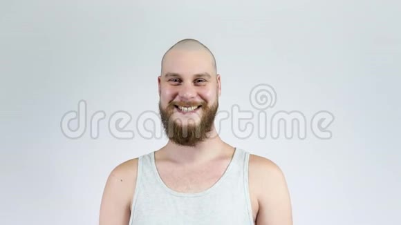 一个留着胡子的秃头男人对着镜头大笑视频的预览图