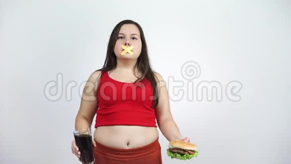 一个用胶带粘住嘴巴的女孩在找汉堡包你不能吃垃圾食品视频的预览图