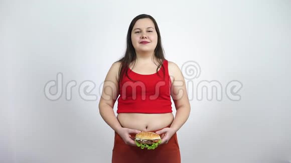 微笑的胖女孩吃汉堡包快餐暴食不健康的生活方式视频的预览图