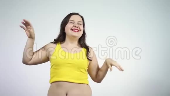 那个穿着黄色衬衫的胖乎乎的女孩跳舞微笑着身体正面概念视频的预览图