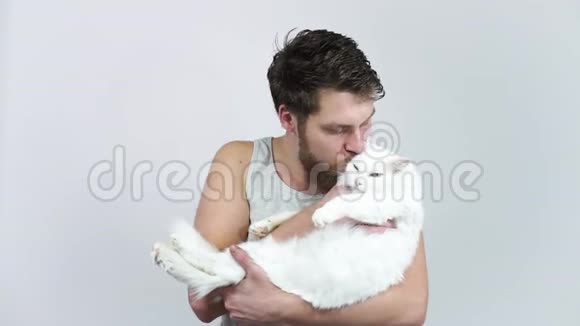 一个长胡子的男人亲吻一只白猫爱宠物和主人异色性视频的预览图