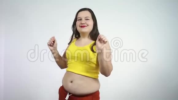 体重超重的胖女孩正在跳舞敲他的肚子视频的预览图