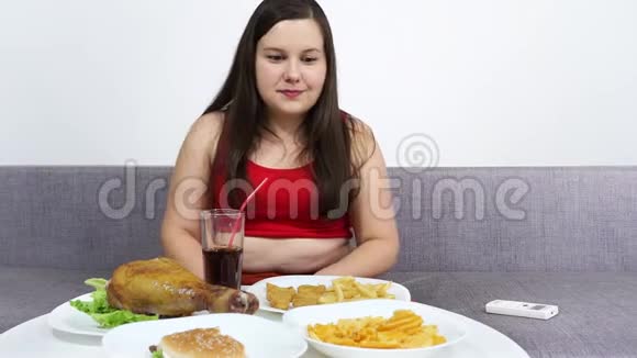 肚子胖的女孩吃炸鸡看电视视频的预览图