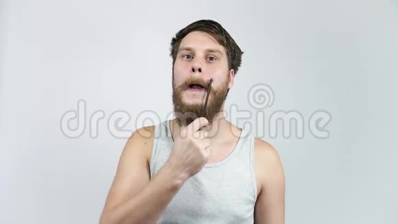 一个梳胡子和胡须的人男人把美带到镜子前视频的预览图