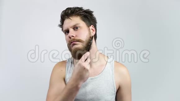男人梳胡子嬉皮士刷他的姜胡子视频的预览图