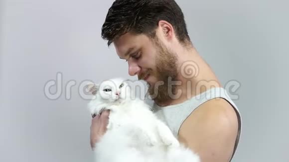 那个留胡子的家伙抱着他心爱的宠物最喜欢的猫有不同的眼睛视频的预览图