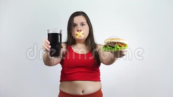 饮食年轻的女人嘴上有胶带阻止她吃垃圾食品视频的预览图