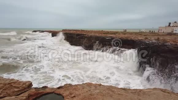 高浪在海岸线的岩石上破碎视频的预览图