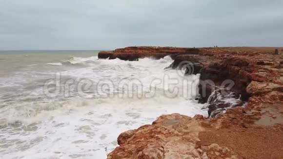 海浪拍打着岩石海浪拍打着海岸岩石海浪拍打着泡沫岩石视频的预览图