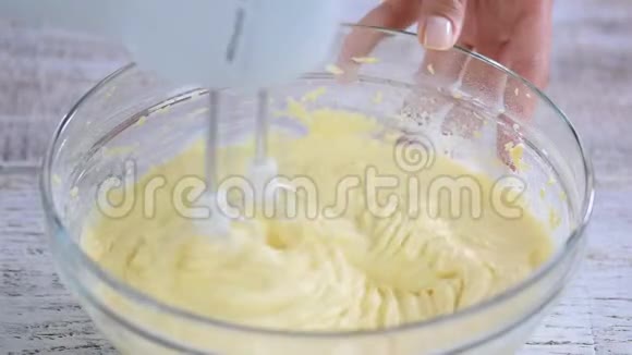 蛋糕面糊与搅拌器混合在玻璃碗中视频的预览图