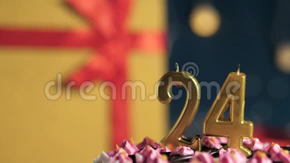 生日蛋糕24号金色蜡烛用打火机点燃蓝色背景礼品黄色盒子用红丝带系好视频的预览图