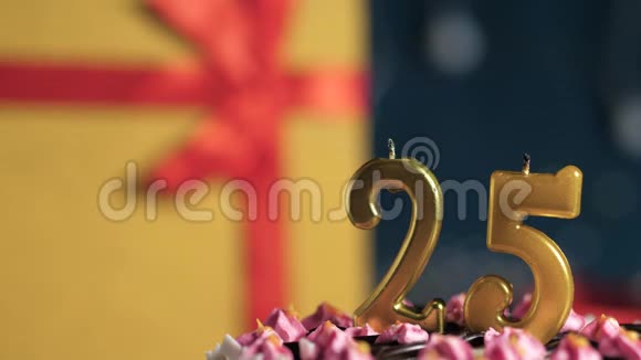生日蛋糕25号金色蜡烛用打火机点燃蓝色背景礼品黄色盒子用红色丝带系好视频的预览图