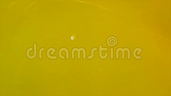 单水滴慢速运动接近黄色背景液体表面视频的预览图