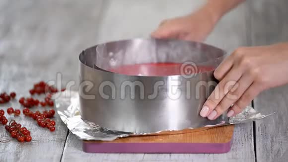 厨师从红色醋栗慕斯蛋糕上取出一个金属环模具视频的预览图