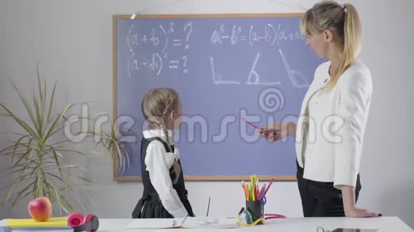 小白种人女孩和成年妇女从黑板转向相机竖起大拇指中学女生视频的预览图