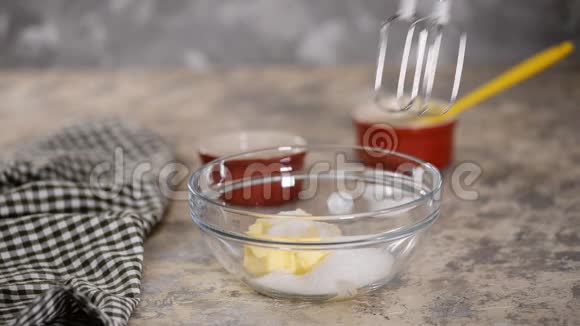 女人用搅拌机搅拌黄油和糖在碗里搅拌原料视频的预览图