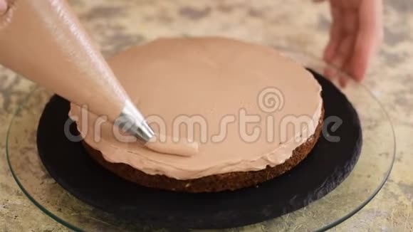 糕点厨师在厨房做蛋糕女用手捏巧克力奶油视频的预览图