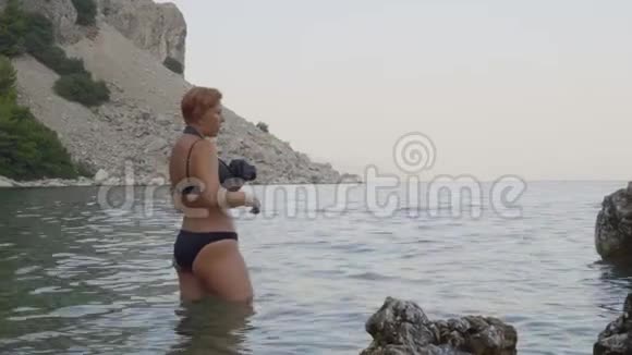 站在海上的女摄影师给模特做指导视频的预览图