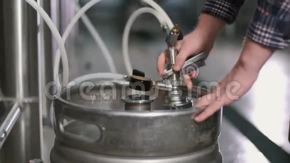 一个男性啤酒商把一个桶连接到一个啤酒罐然后装满啤酒特写镜头视频的预览图