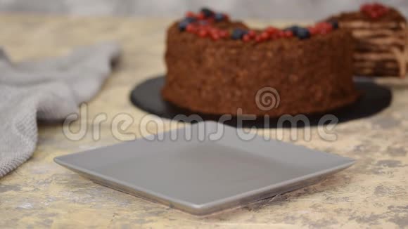 法国巧克力拿破仑蛋糕的膨化糕点与浆果在盘子特写视频的预览图