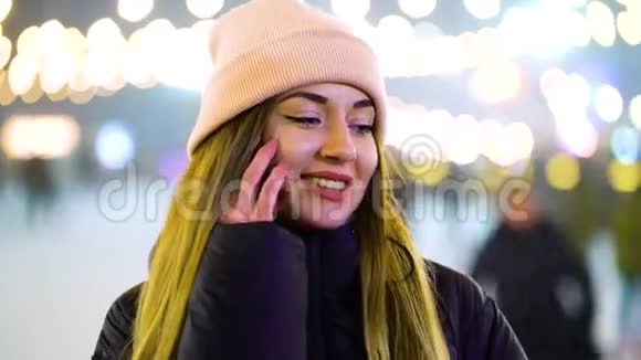 穿着冬装的积极女孩在溜冰场打电话视频的预览图