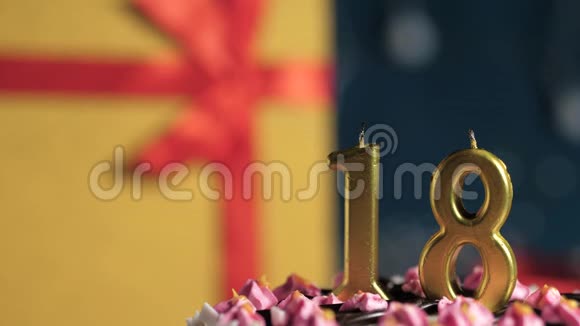生日蛋糕18号金色蜡烛用打火机点燃蓝色背景礼品黄色盒子用红丝带系好视频的预览图