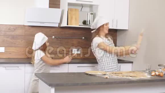 快乐的白种人家庭在厨房里玩和跳舞表演他们的胜利之舞视频的预览图