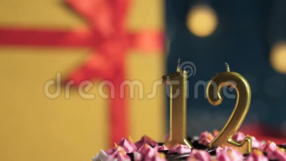生日蛋糕12号金色蜡烛用打火机点燃蓝色背景礼品黄色盒子用红丝带系好视频的预览图