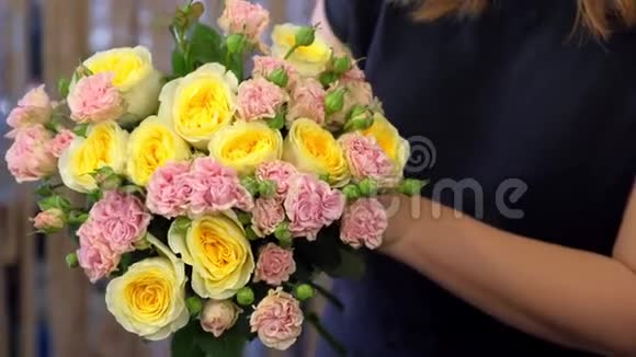 女花匠用不同种类的玫瑰做花束双手特写视频的预览图