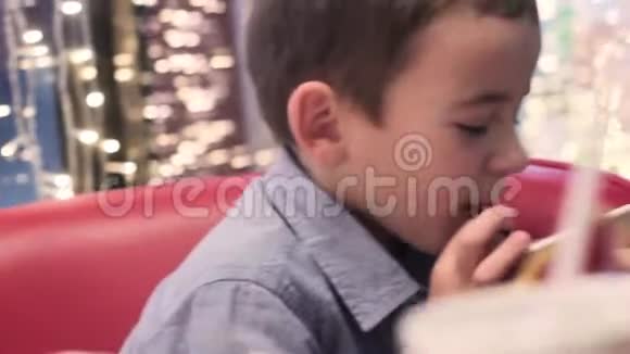 男孩从女人妈妈的手里拿着吸管喝饮料视频的预览图