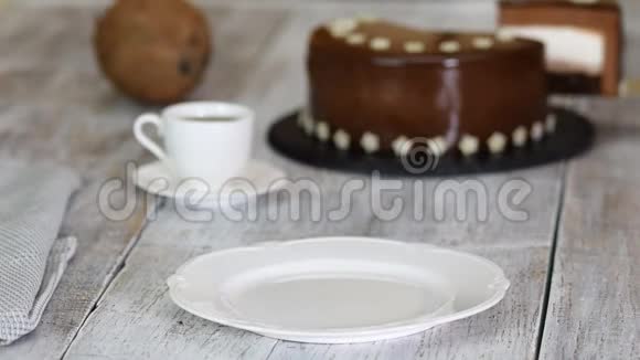 一块巧克力慕斯蛋糕椰子馅在旧的木制背景上配镜面釉的慕斯蛋糕视频的预览图