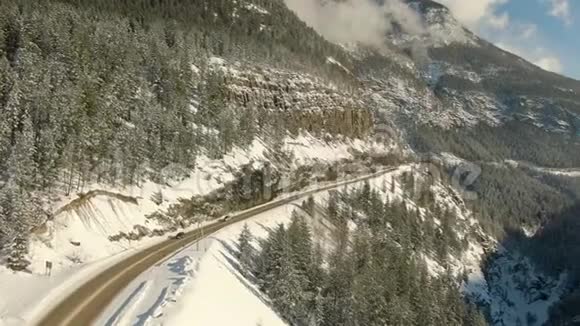 无人驾驶飞机观看加拿大山景之间山谷的一条风景公路视频的预览图
