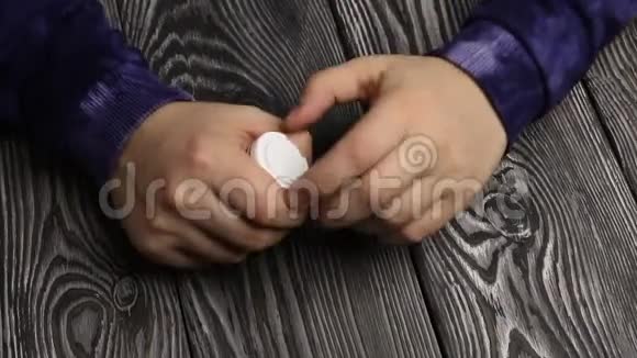 一个人打开一罐药丸他把一把白色药丸倒进他的手掌从手到手用拳头捏视频的预览图