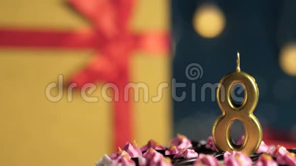 生日蛋糕8号金烛用打火机点燃蓝色背景礼品黄盒用红丝带绑好关闭视频的预览图