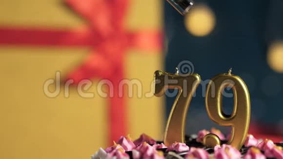 生日蛋糕79号金色蜡烛用打火机点燃蓝色背景礼品黄色盒子用红丝带系好视频的预览图