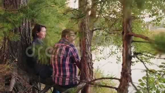 中老年夫妇坐在河边放松的后景视频的预览图