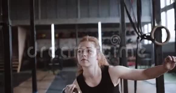 年轻运动员红头发职业运动员女子在大型大气体操中举重视频的预览图