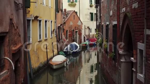 典型的威尼斯狭窄的运河有停泊的船只古老的传统建筑视频的预览图