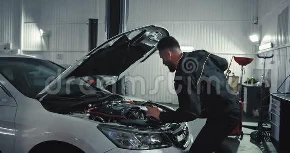 汽车修理工在修理汽车时享受一天的工作他在前面跳舞动作滑稽视频的预览图
