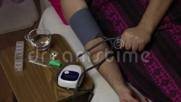 那个病人躺在一张铺着毯子的床上用血压监测仪测量血压他拿走了那个装置视频的预览图