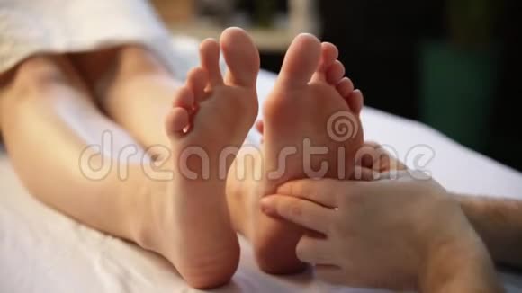 按摩治疗师的男性手做女性足部按摩视频的预览图