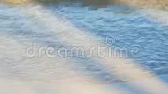 海浪在阳光下的沙岸上冲浪视频的预览图