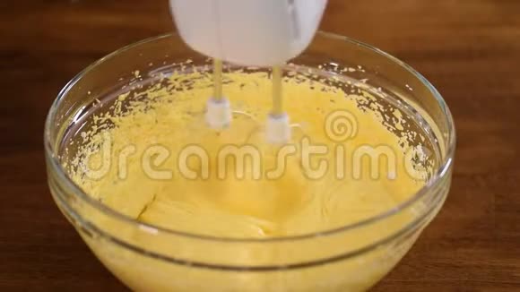 在面团中加入面粉用电动搅拌器搅拌碗面特写视频的预览图