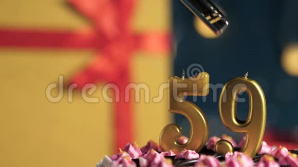 生日蛋糕59号金色蜡烛用打火机点燃蓝色背景礼品黄色盒子用红丝带系好视频的预览图