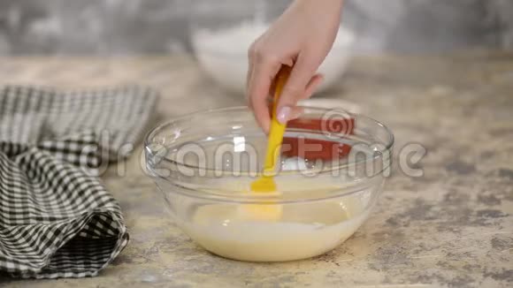 女性添加明胶到碗与奶油混合物视频的预览图