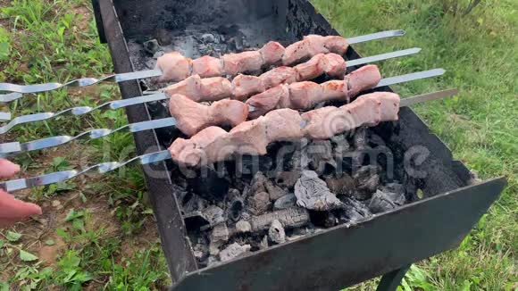 一个人在花园后院烧烤炉上烧烤肉串烧烤炉上烧烤肉串烧烤炉里的烟和热视频的预览图