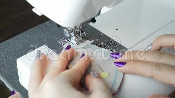 一只雌性的手通过缝纫机推材料视频的预览图