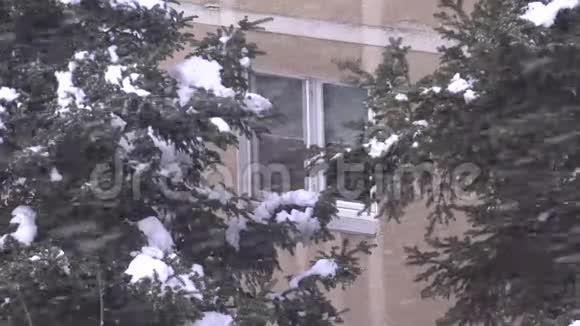 窗户上下雪城市里的暴风雪冬季景象城市里的暴风雪景色视频的预览图